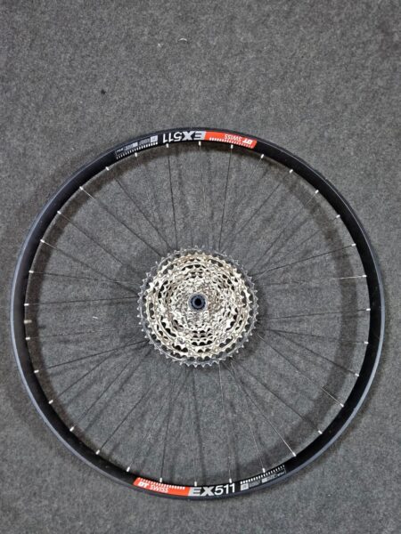 Rueda de bicicleta sin neumático en suelo de cemento.