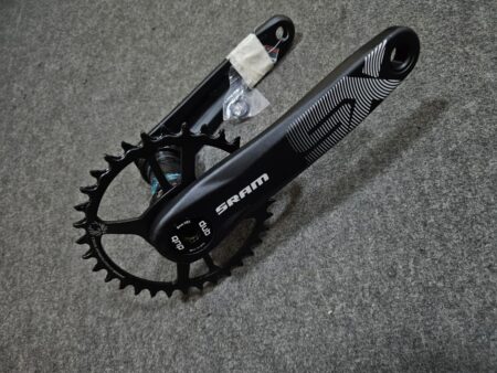 Cinta de bicicleta SRAM con plato y bielas negras en fondo gris.