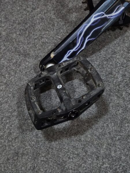 Pedal de bicicleta sin plataforma, usado y desgastado.